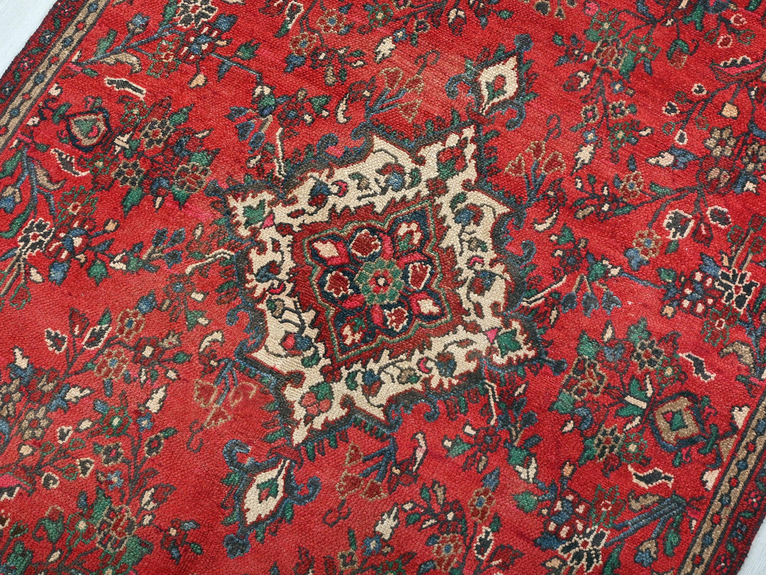 a red rug with a floral design on it