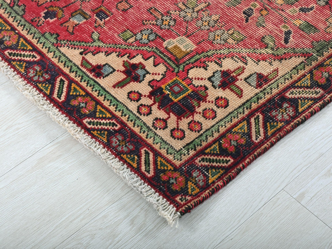 a red rug with a multicolored design on it