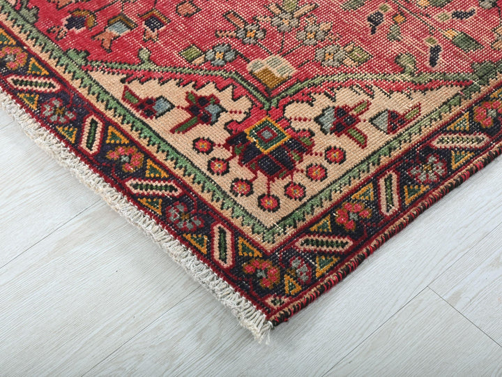 a red rug with a multicolored design on it