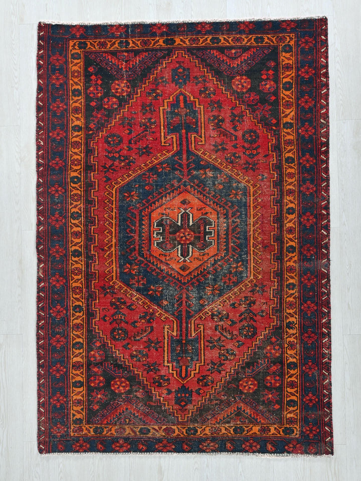 a red and blue rug on a wooden floor