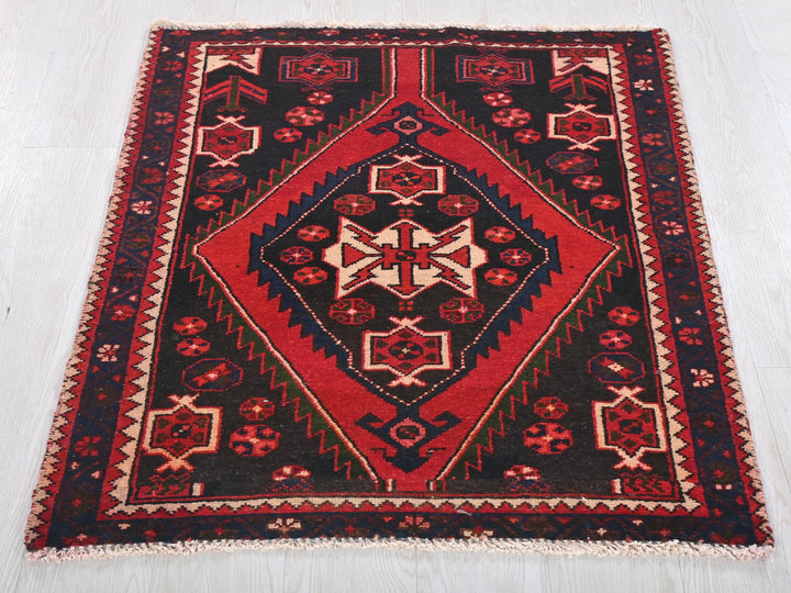 a red and black rug on a white floor