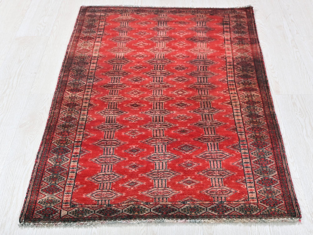 a red rug on a white wooden floor