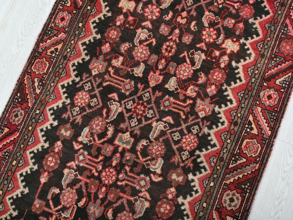a red and black oriental rug on a white floor