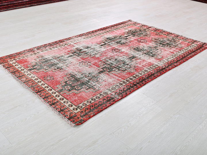 a red and black rug on a white floor