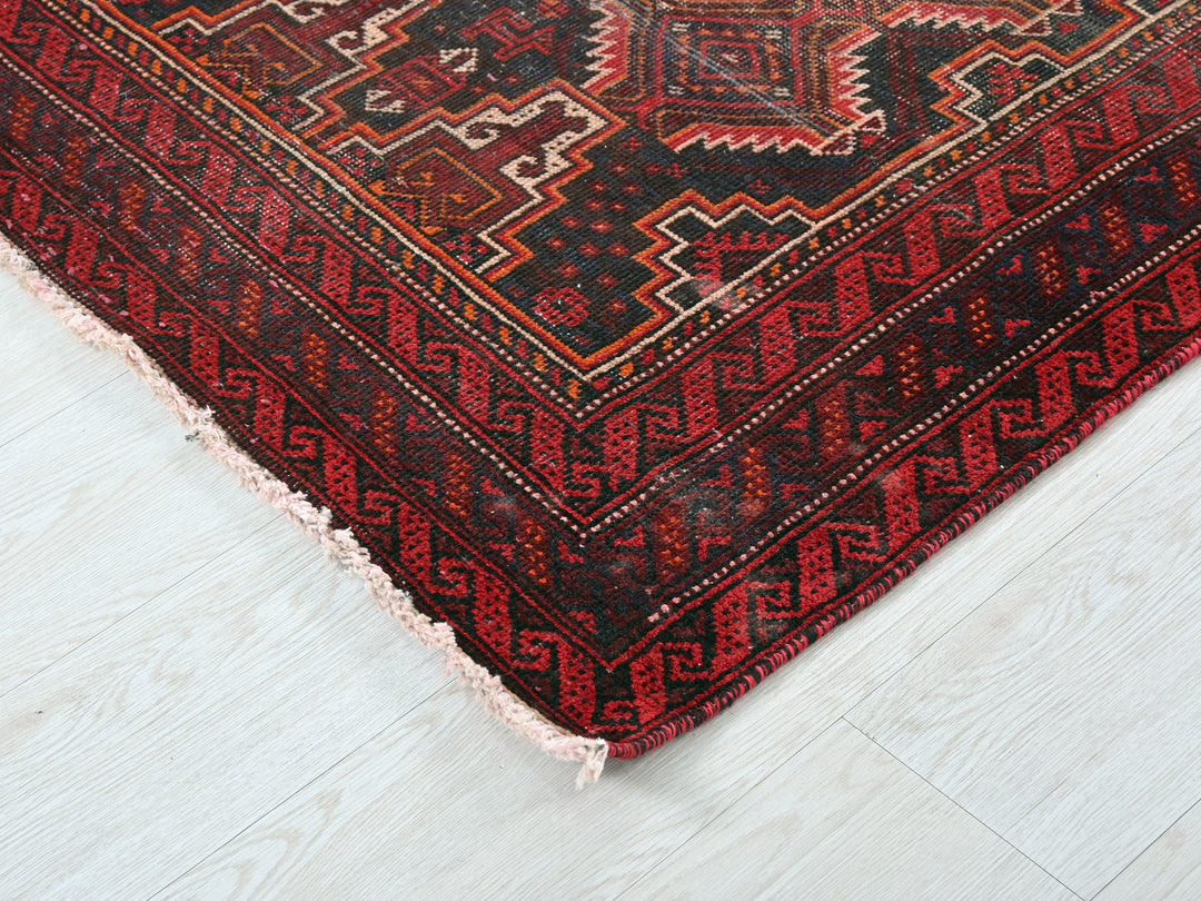 a red and black rug on a white floor