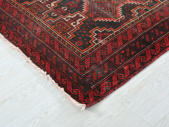 a red and black rug on a white floor