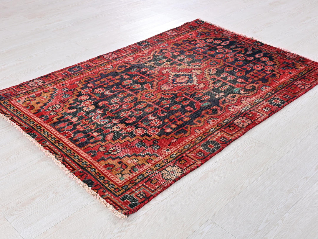 a red and black rug on a white floor