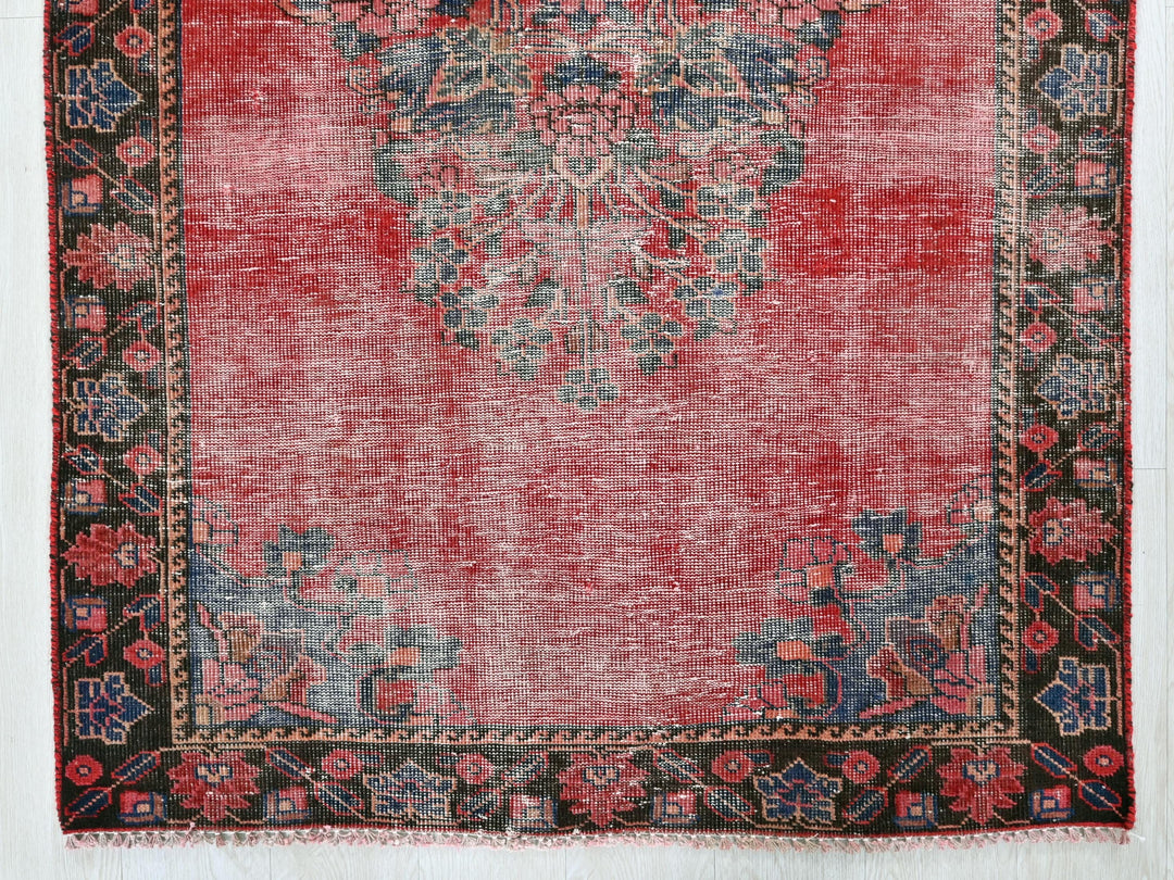 a red rug with a black border on a white background