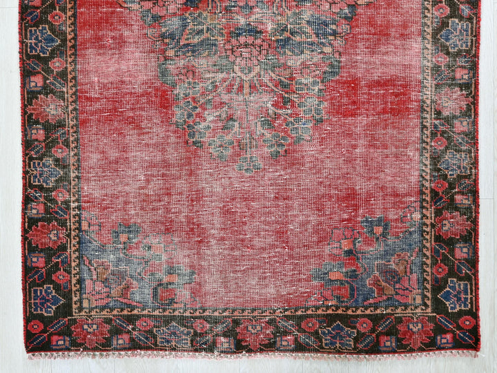 a red rug with a black border on a white background