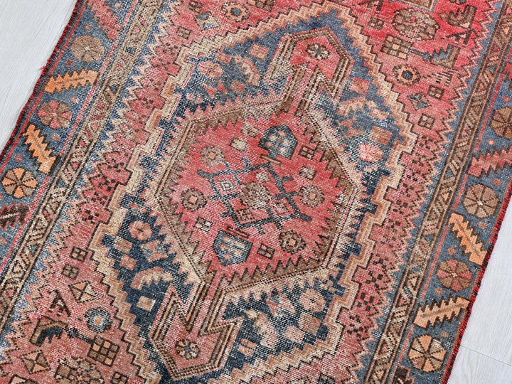 a red and blue oriental rug on a white floor