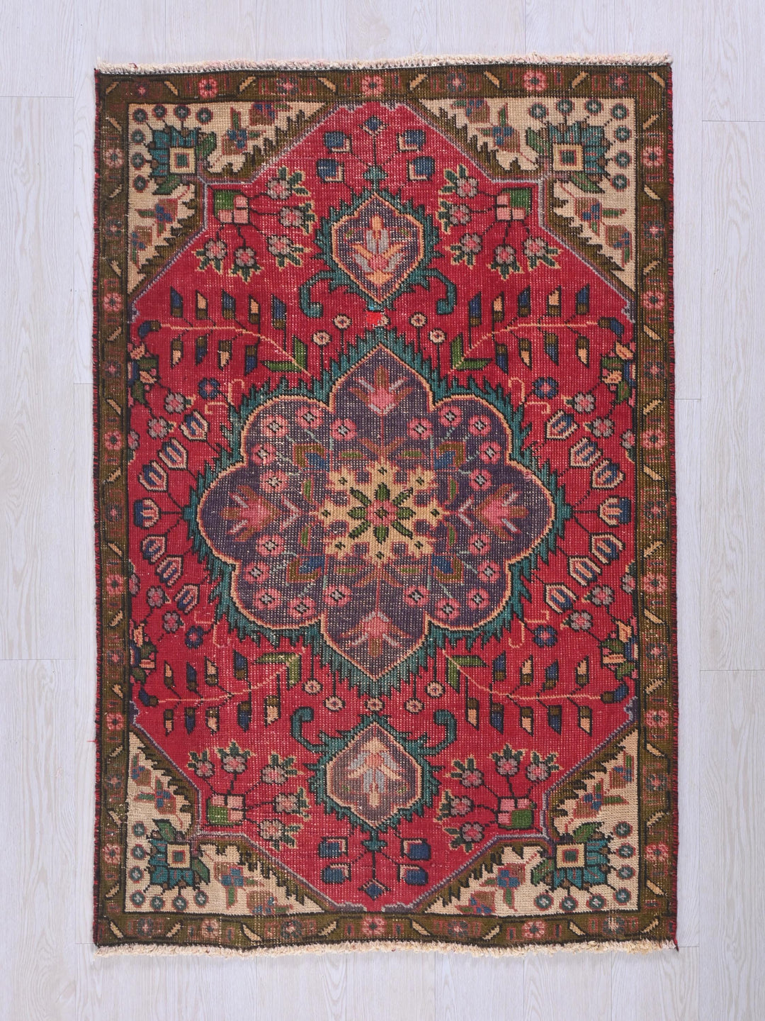 a red rug with a floral design on it