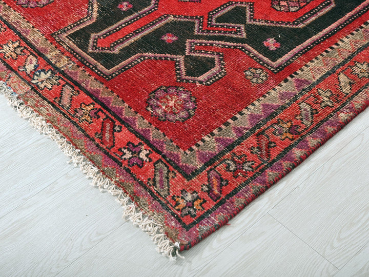 a red rug with a black design on it