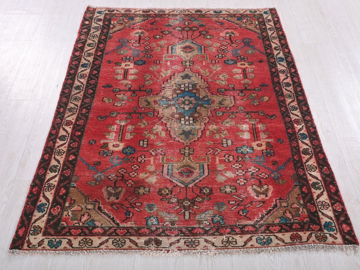 a red rug with a design on the middle of it