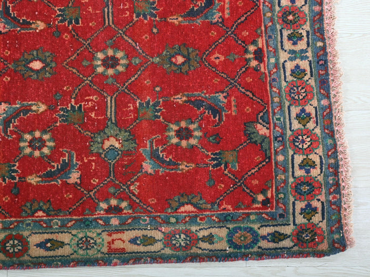 a red rug with a blue border on a white floor