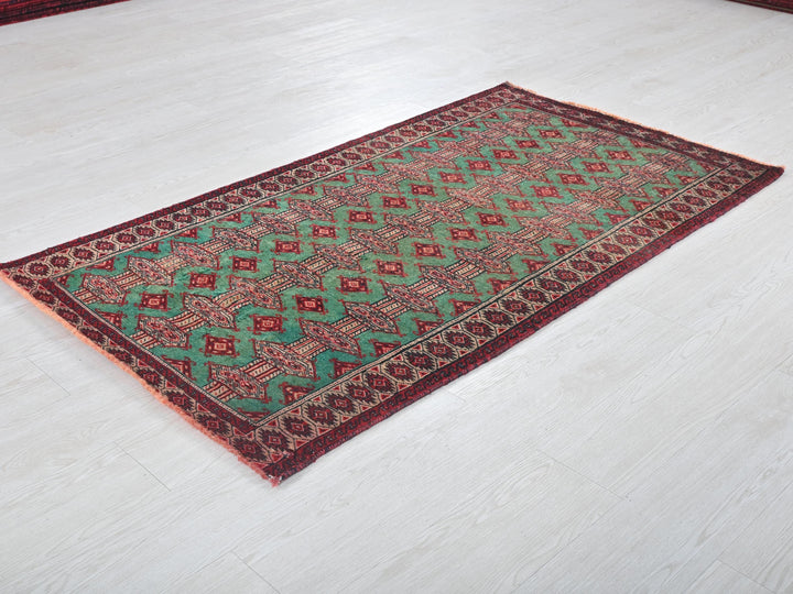 a green and red rug sitting on top of a white floor