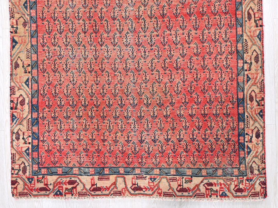a red and blue rug on a white surface