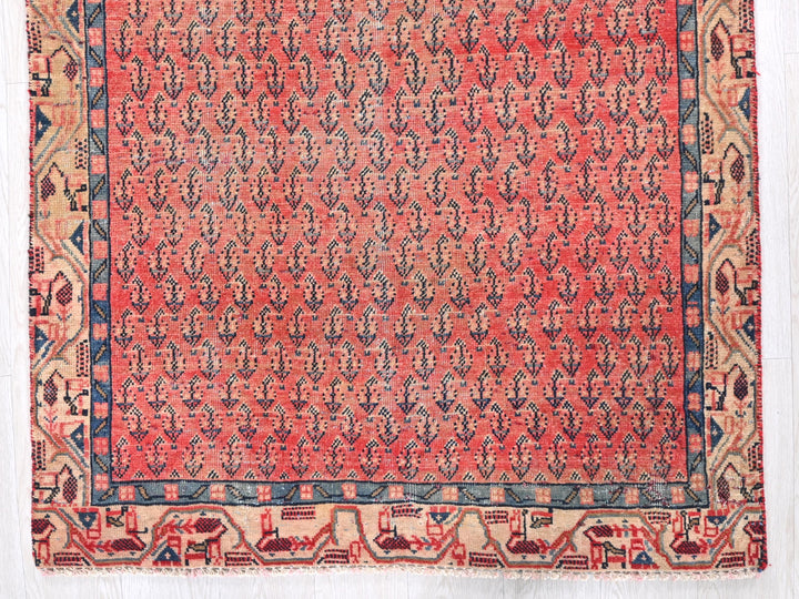 a red and blue rug on a white surface