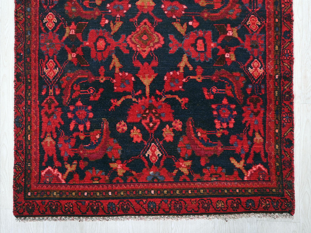 a red and black oriental rug on a white wall