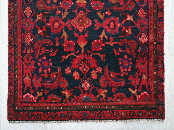 a red and black oriental rug on a white wall