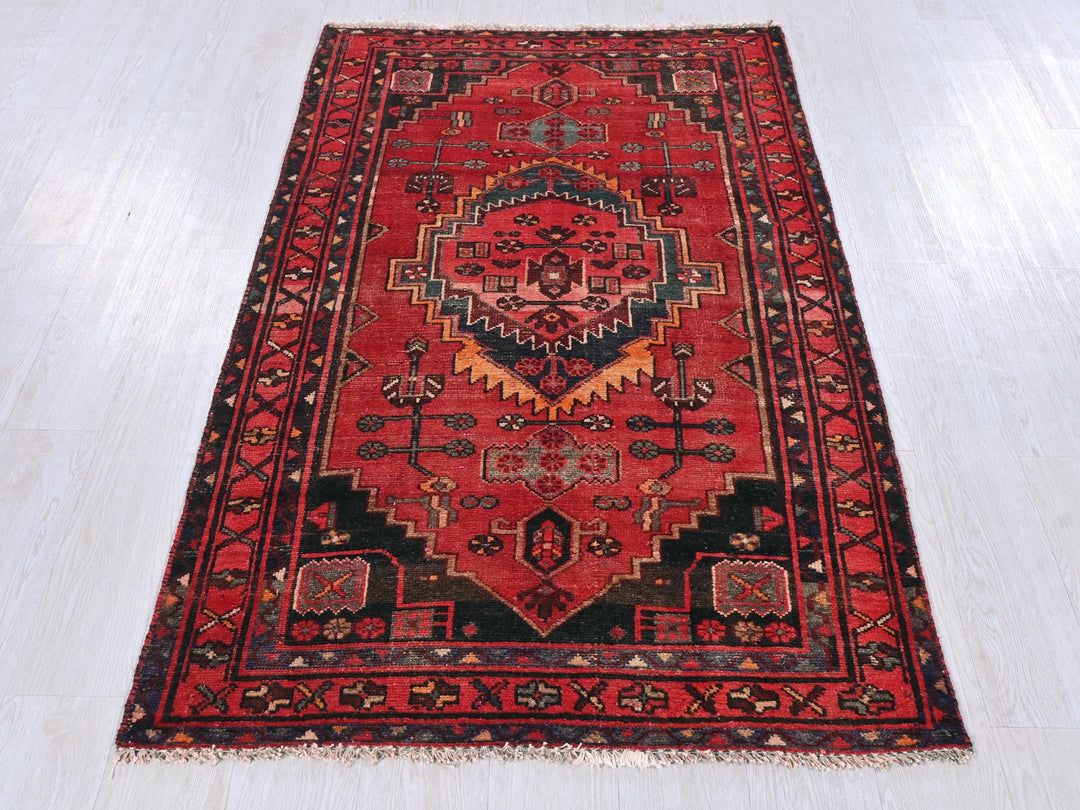 a red rug with a black border on a white floor