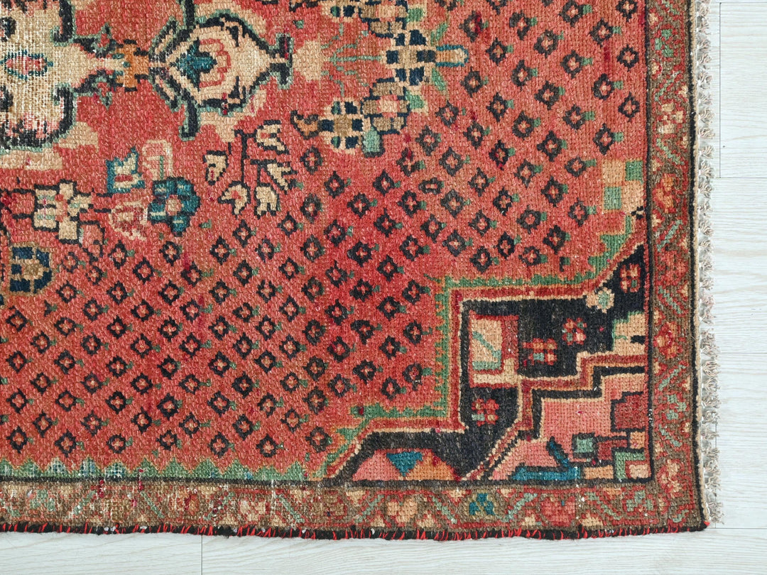 a red rug with a floral design on it
