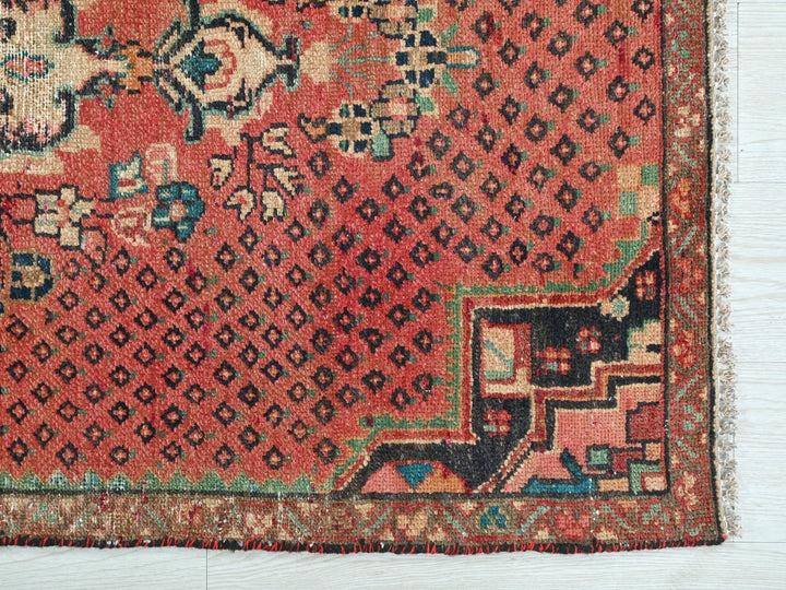 a red rug with a floral design on it