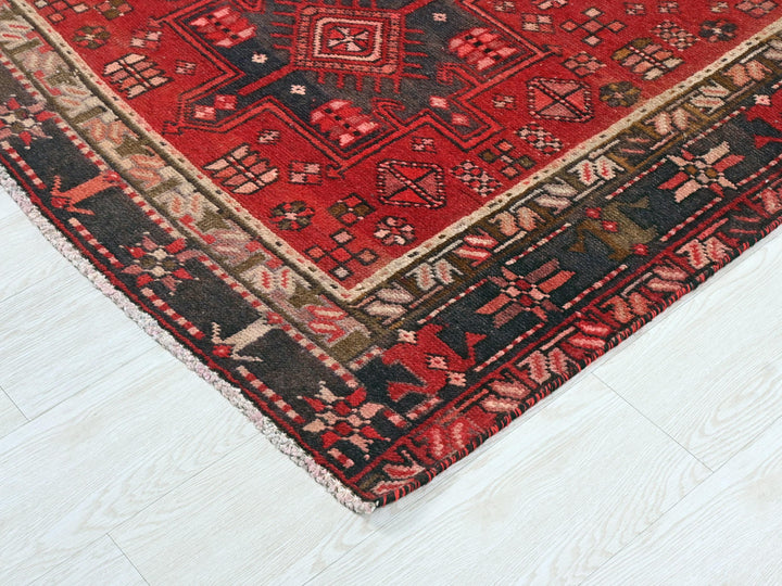a red oriental rug on a white wooden floor