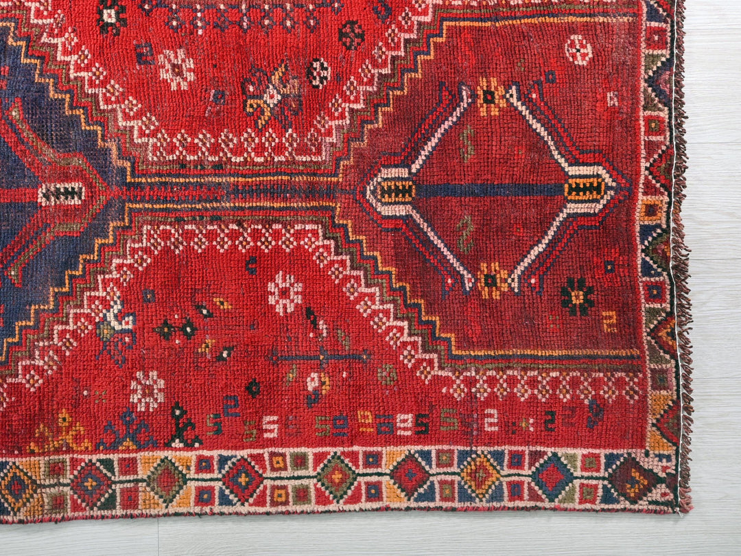 a red rug with a design on it