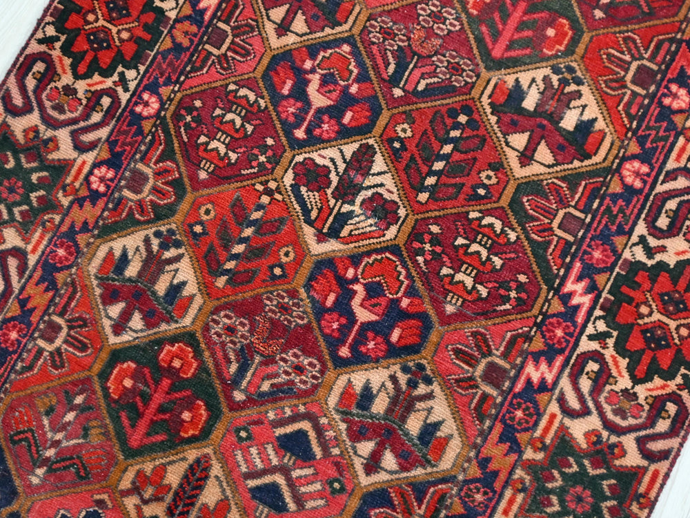 a red and blue oriental rug on a white floor