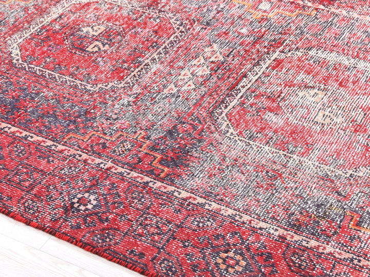 a red and blue rug with a wooden floor