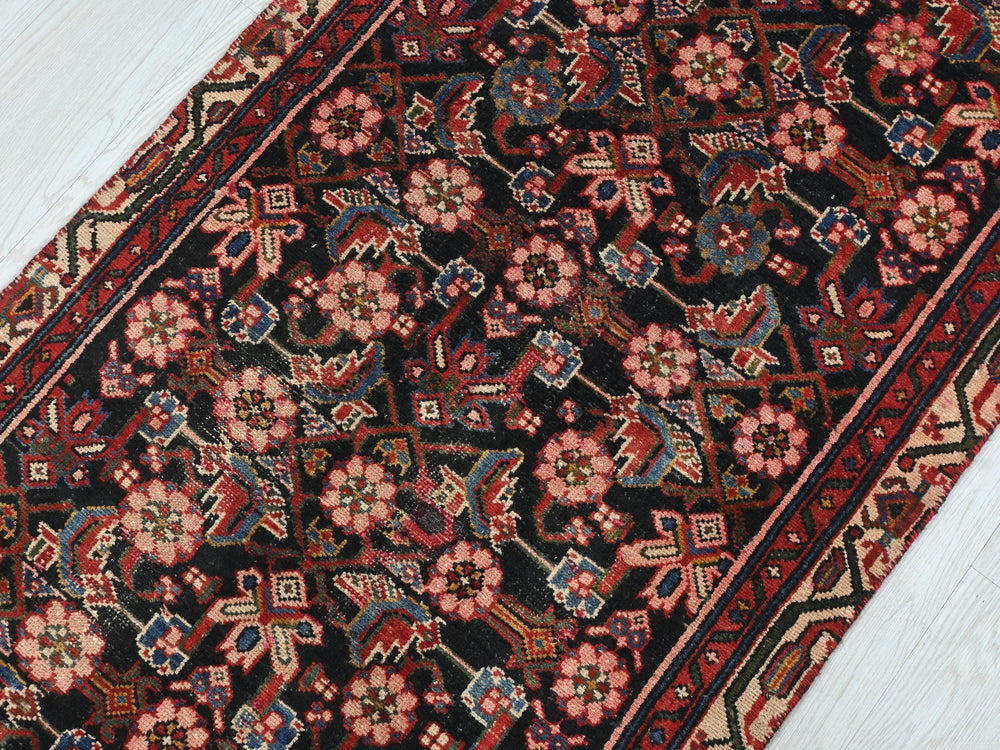 a red and black oriental rug on a white floor