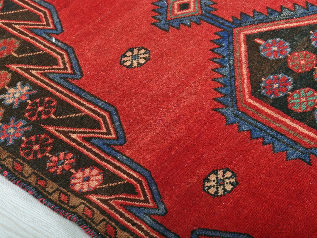 a close up of a red rug on a white surface