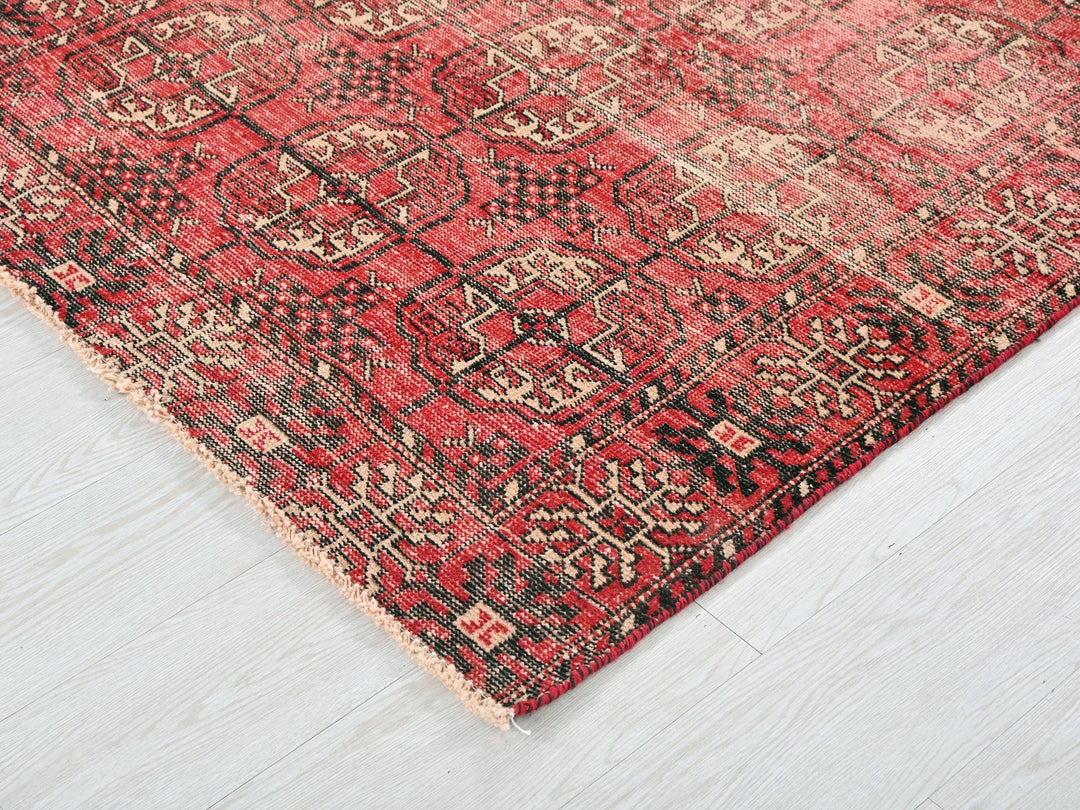 a red and black rug on a white floor