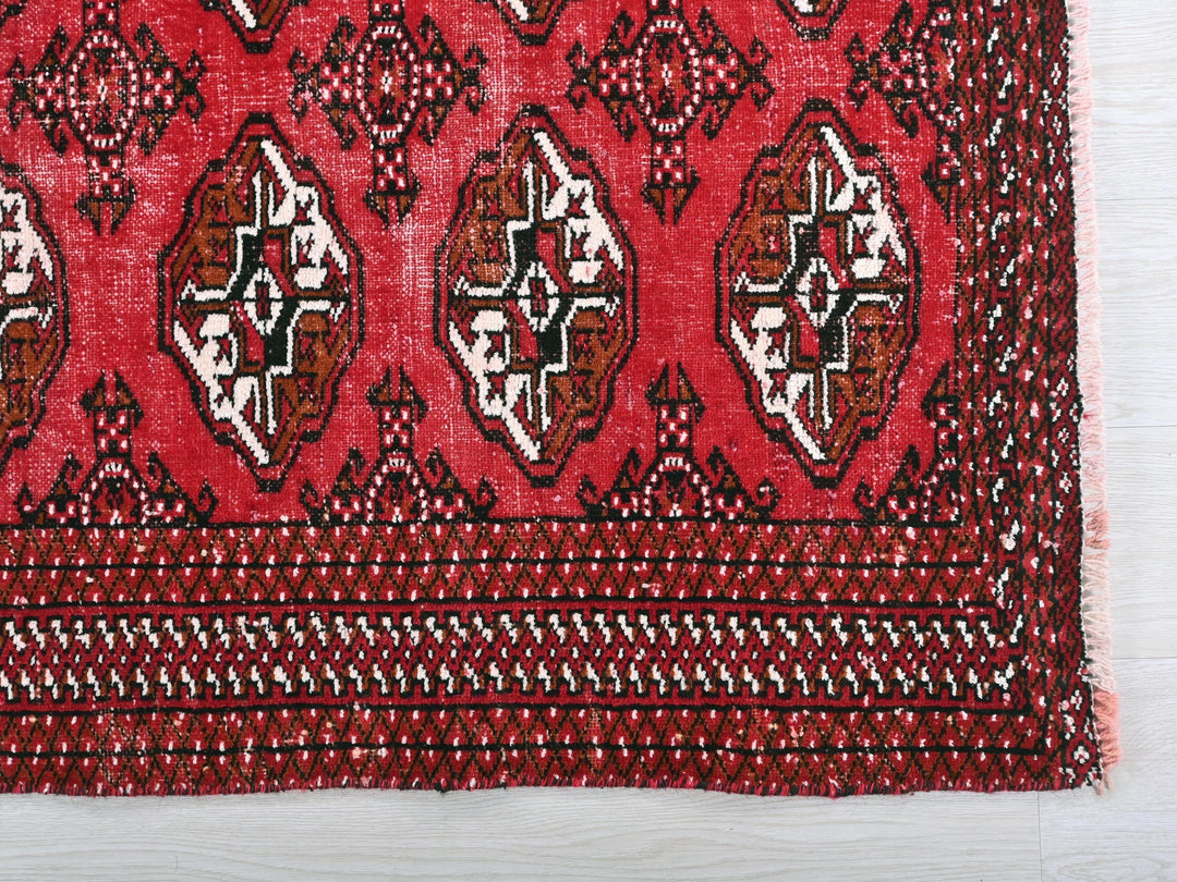 a close up of a red rug on a white surface