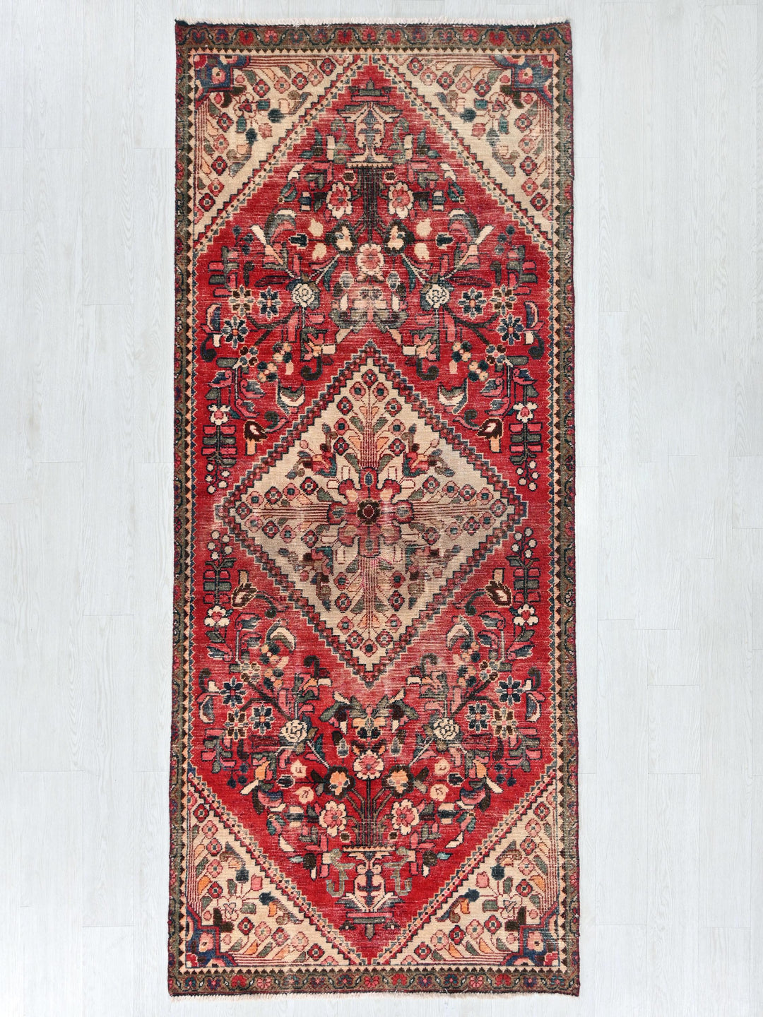 a red rug hanging on a white wall