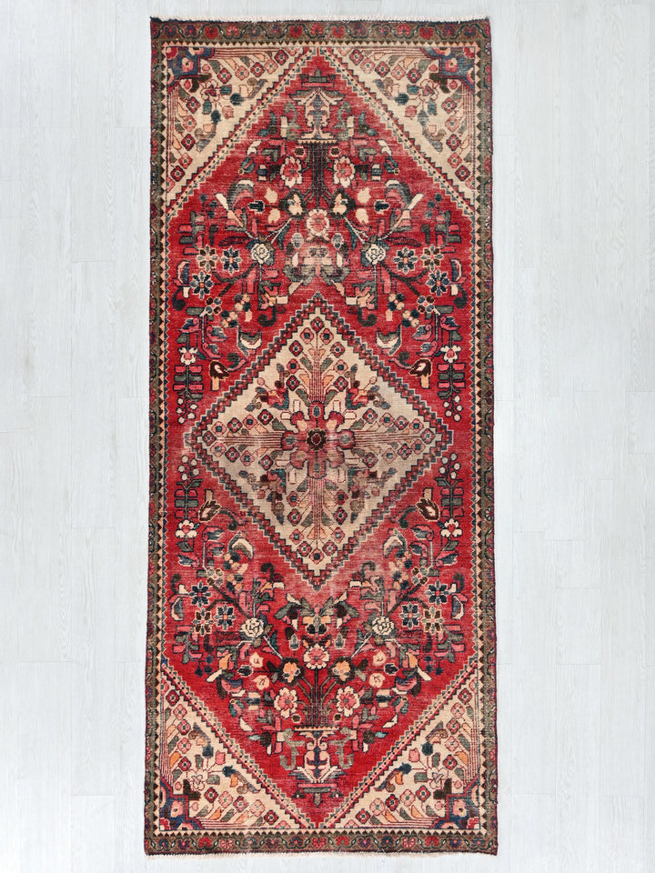 a red rug hanging on a white wall