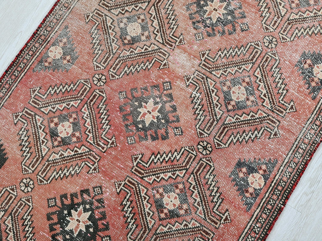 a red and black oriental rug on a white floor