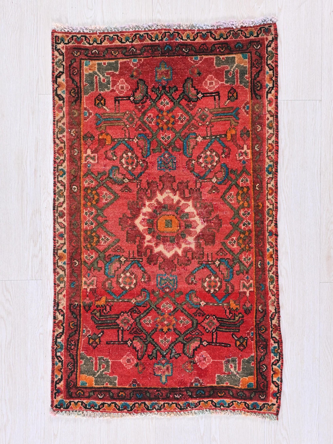 a red rug on a white wooden floor
