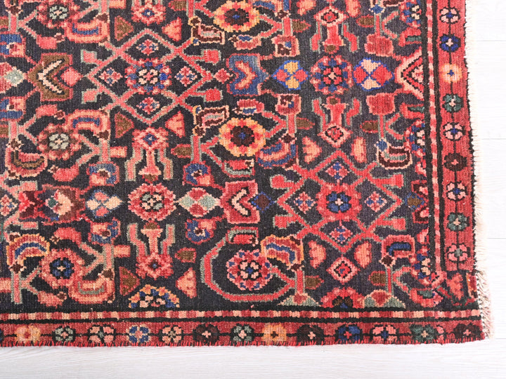 a red and black oriental rug on a white floor