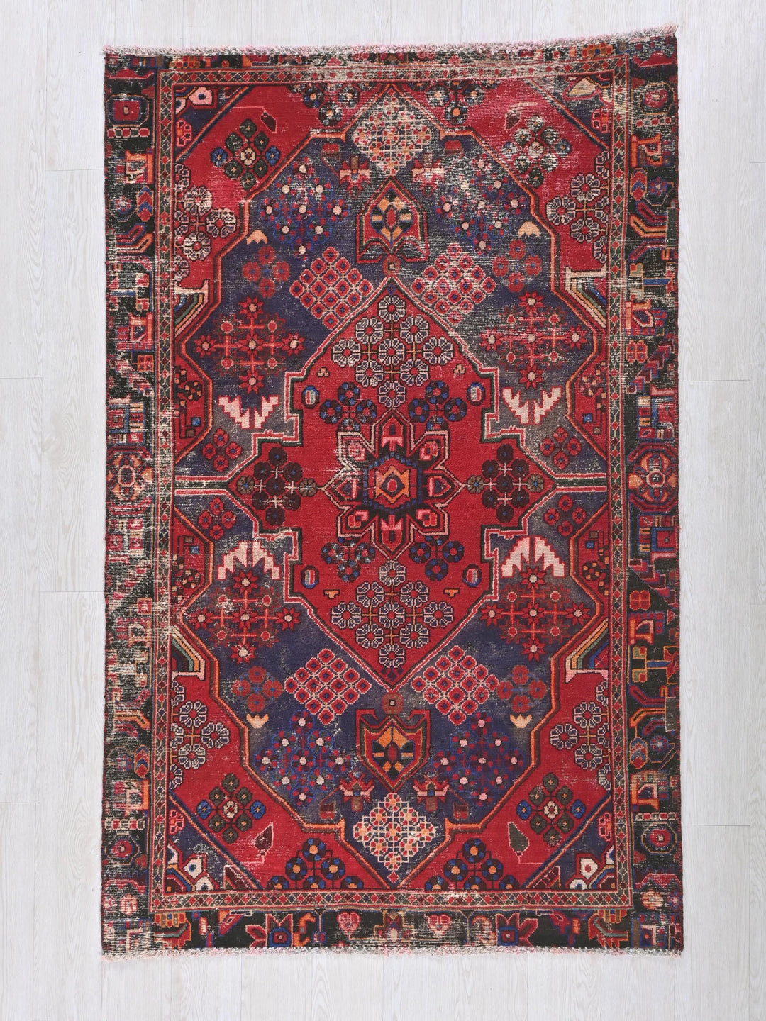 a red and blue rug on a white floor
