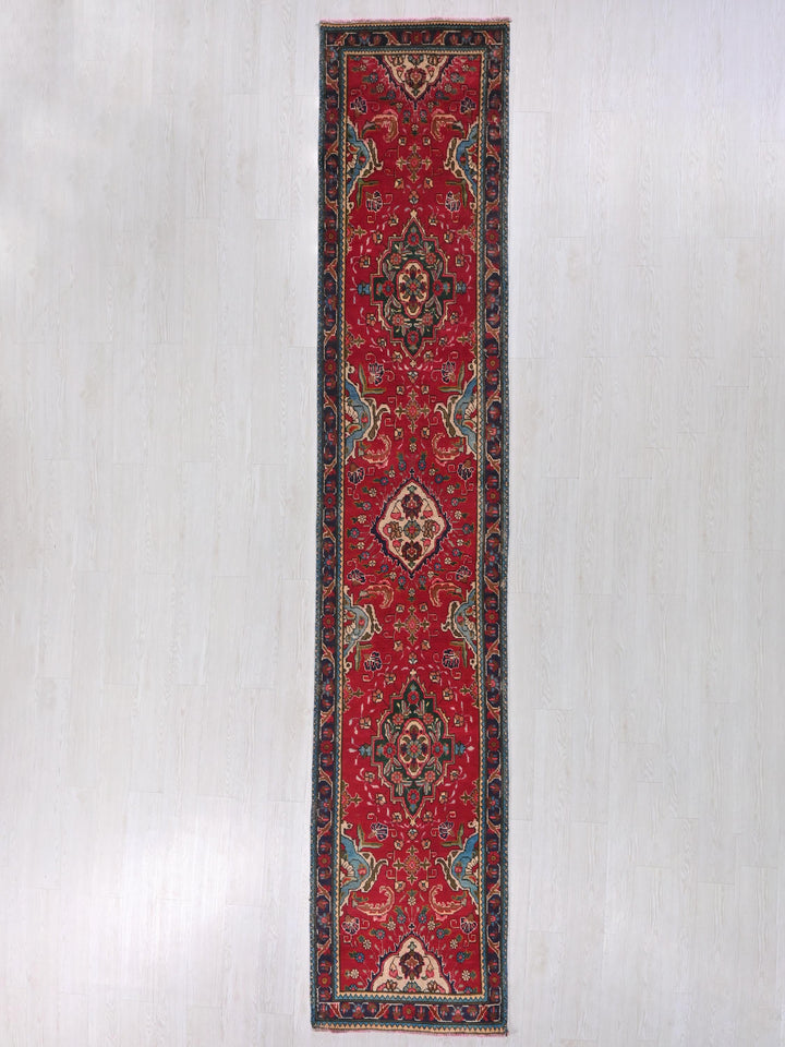 a red rug hanging on a white wall