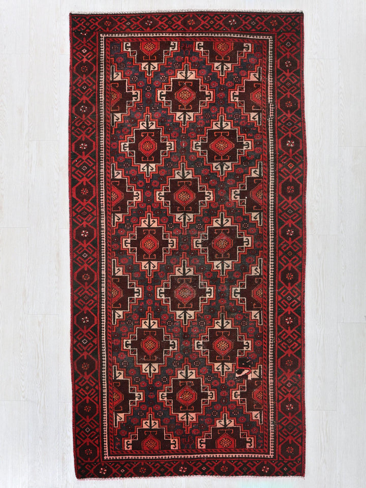 a red and black rug on a white floor