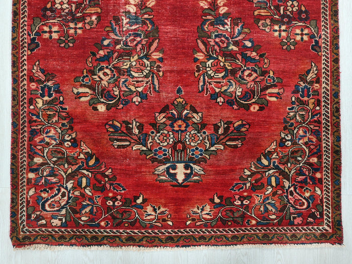 a red rug with a floral design on it