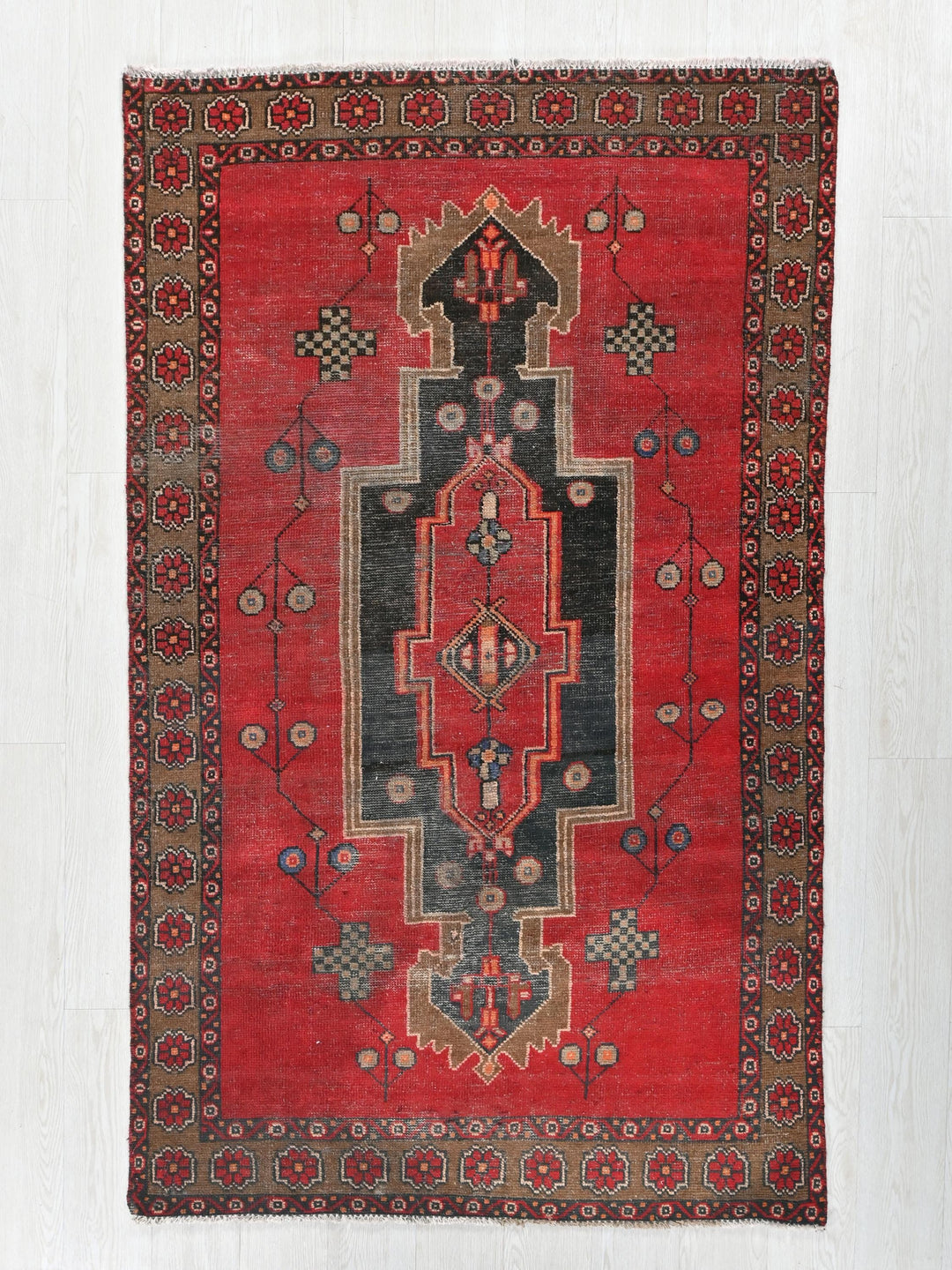 a red rug with a design on the middle of it
