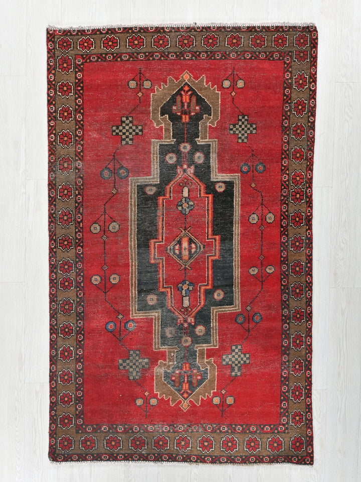 a red rug with a design on the middle of it
