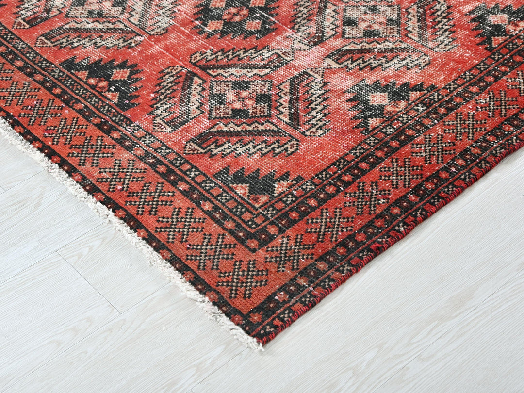 a red and black oriental rug on a white floor