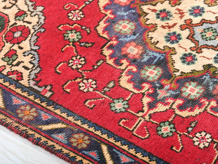 a close up of a red rug on a wooden floor