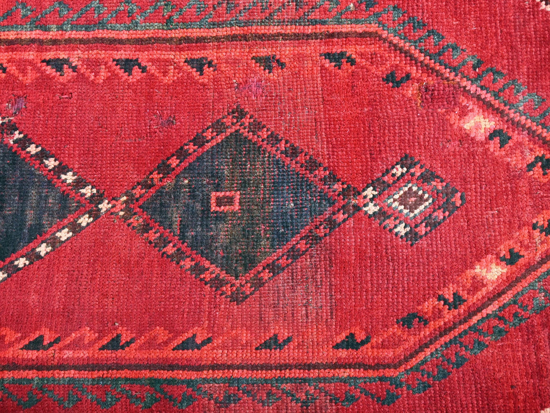 a close up of a red rug with a diamond pattern