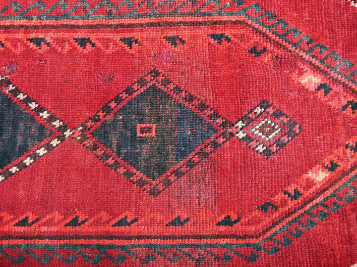 a close up of a red rug with a diamond pattern