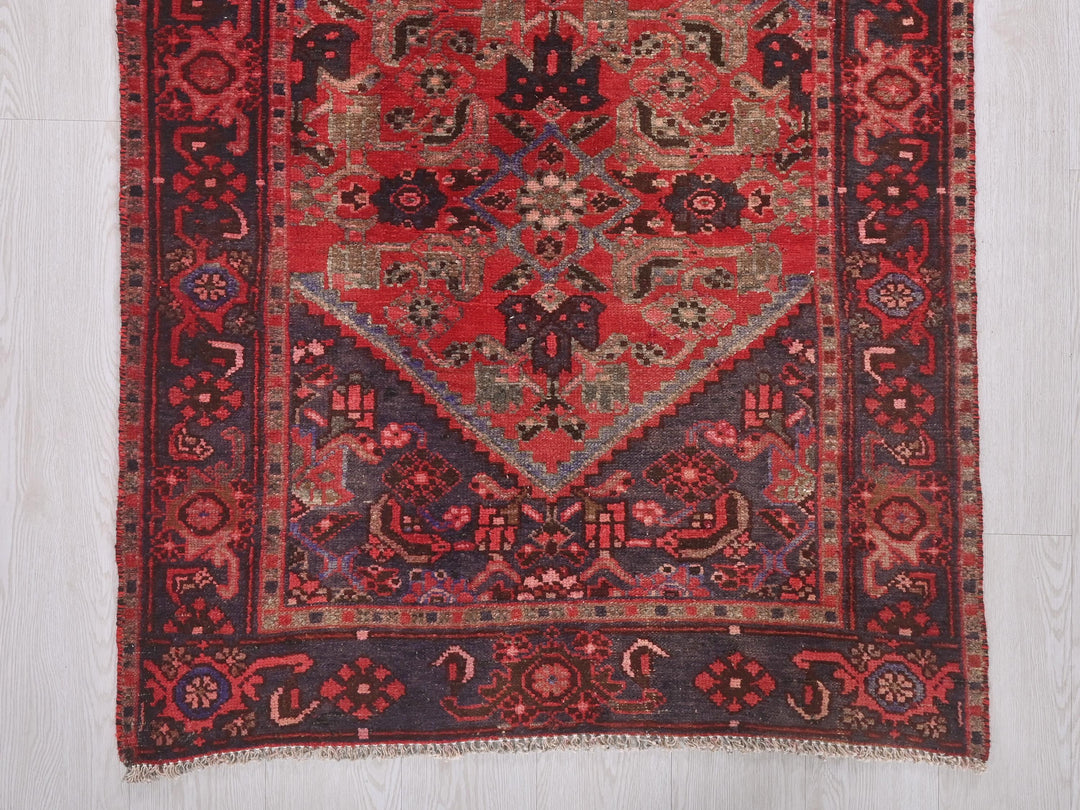 a red rug with a diamond shaped design on it